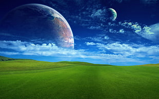 green grass field with two planets in the sky graphics