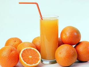 orange fruits placed near clear drinking glass with orange juice