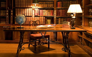 brown wooden table with chairs, books, desk, lamp, table