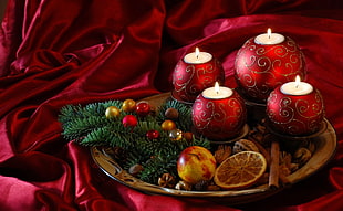 four red tealight candle on brown wooden tray