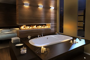 oval bath tub beside fireplace