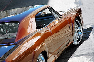 classic orange coupe on gray concrete road