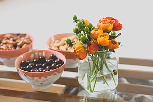orange and red peonies and clear glass vase centerpiece