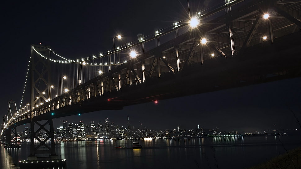 suspension bridge with lighted string lights at night HD wallpaper