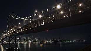 suspension bridge with lighted string lights at night