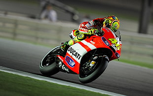 racer in red biker suit riding Ducati sports bike
