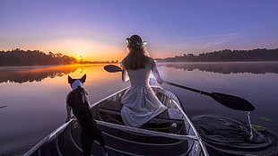 woman wearing white dress rides white boat with adult black and white American pit bull terrier
