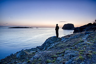 silhouette of person wearing cap standing near blue sea during daytime, washington, san juan islands national monument