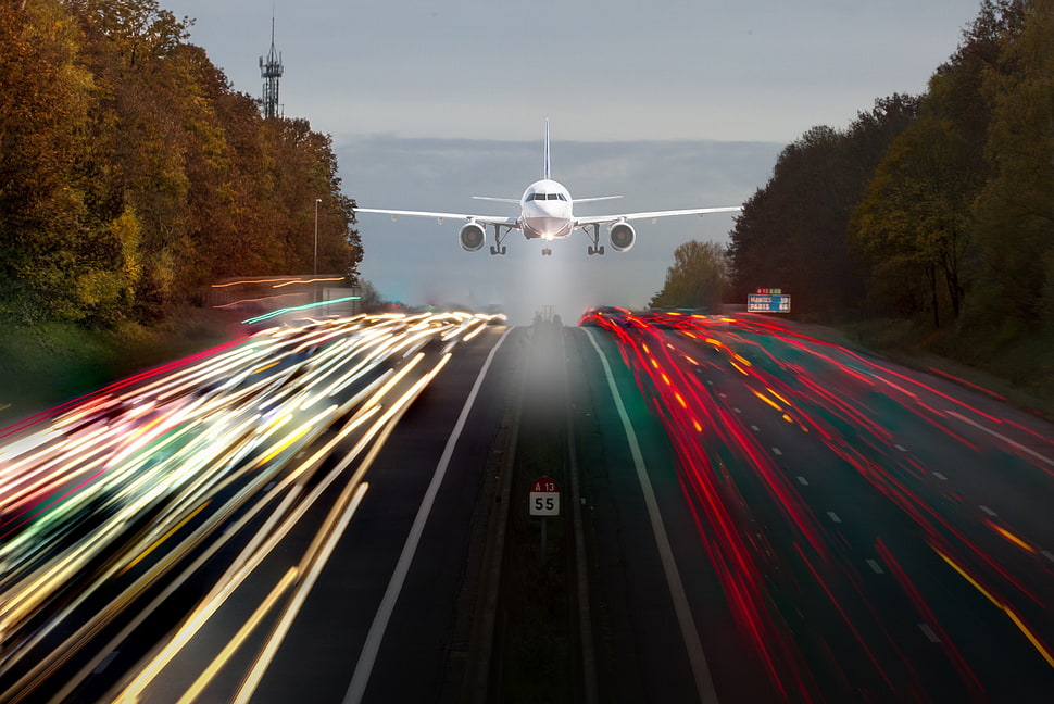 time lapse photo of white commercial plane above road with cars on street HD wallpaper