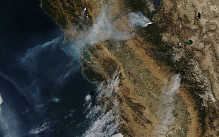 aerial photo of smoking surface near body of water