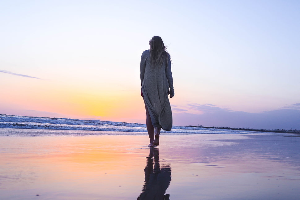 woman in gray cardigan walking on sea shore HD wallpaper