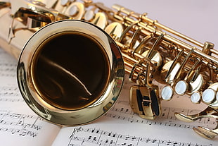 selective focus photography of brass trumpet on musical notes HD wallpaper