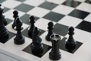 closeup photography of black chess pieces on white and black board HD wallpaper