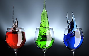 photography of wine glasses with red, green, and blue liquids
