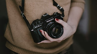 woman holding black Yashica FX-3 SLR camera