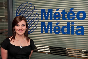 woman in black square neckline blouse standing beside Meteo Media