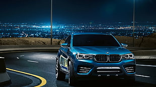 blue BMW sedan on gray asphalt road during nighttime