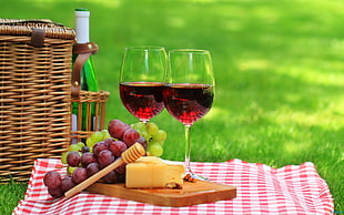 wine glasses and grapes with wicker picnic basket