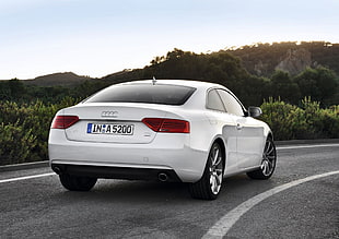 white Audi A-series coupe on gray asphalt road at daytime