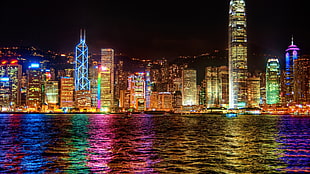 photo of city light near sea during night time