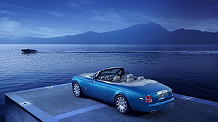 blue convertible near body of water