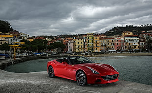 photo of red sports car near on sea