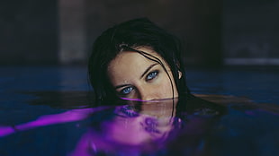 woman with blue eyes and black hair submerged in water