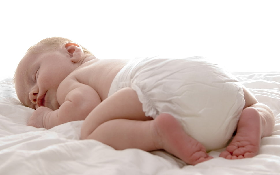 baby's lying on white blanket HD wallpaper