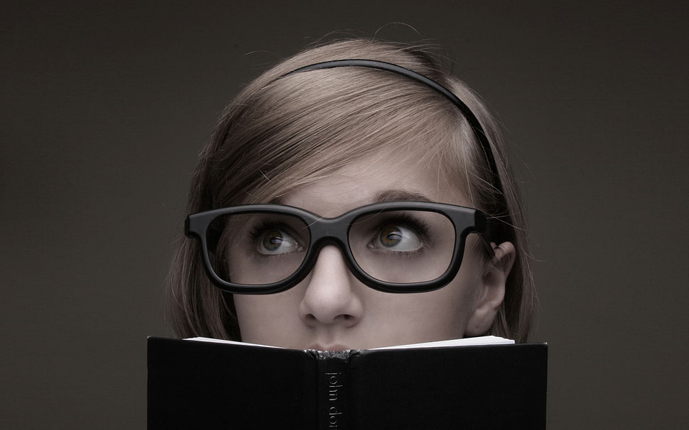 grayscale photo of woman wearing eyeglasses while holding a book HD wallpaper