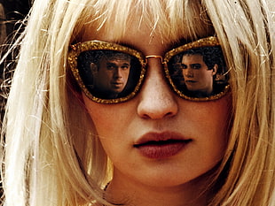 landscape portrait photo of two men faces on blonde haired women's gold glittered framed black lens oversized sunglasses