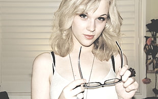 woman holding black framed eyeglasses