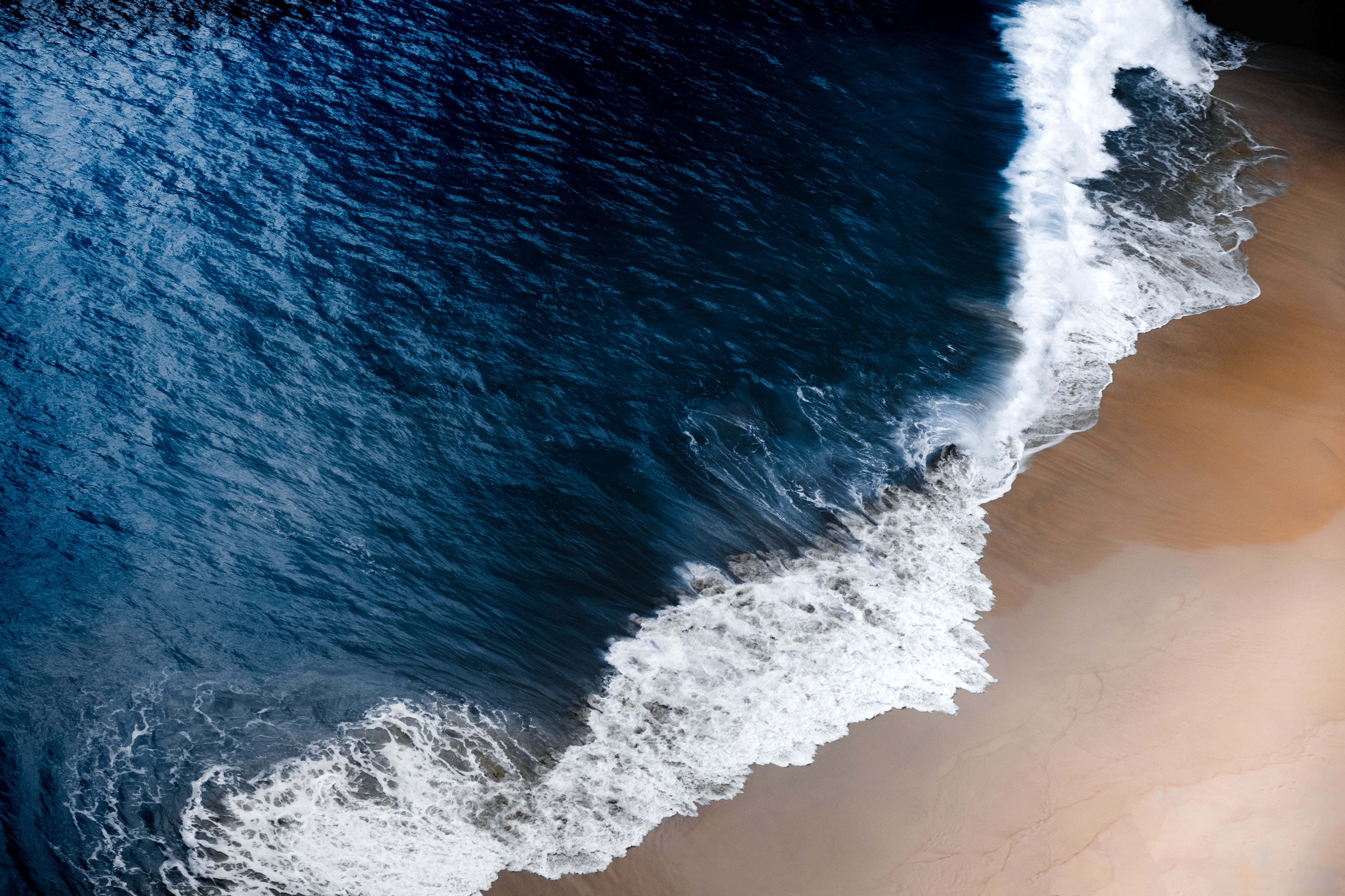 aerial photography of ocean waves on seashore