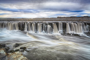 time lapse photo of water falls under cumulus clouds, selfoss
