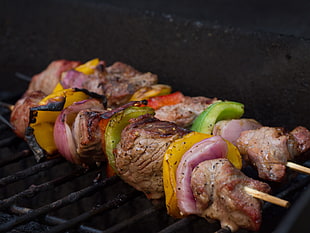 two meat skewers being grilled