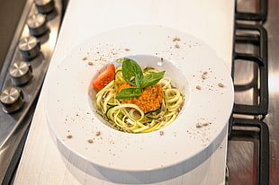 cooked pasta with tomato served on white ceramic plate