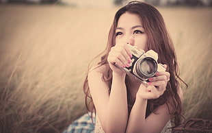 close up photography of woman holding camera