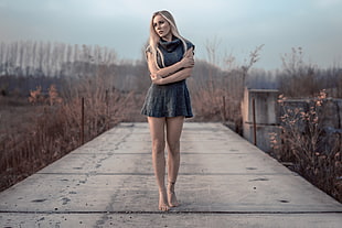 woman in gray mini dress standing on dock