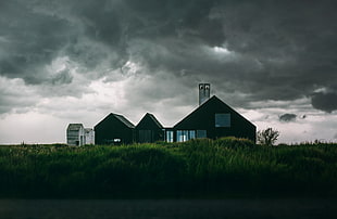 brown and white barn under gray cloudy sky