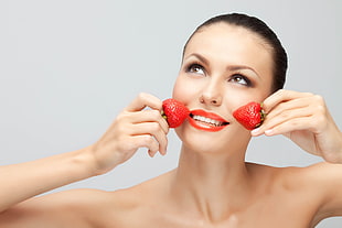 woman holding strawberry fruit in close-up photography