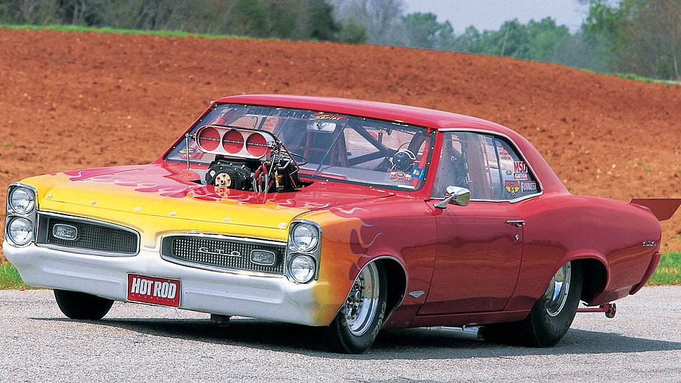 classic red, yellow, and white Pontiac GTO on gray road during daytime HD wallpaper