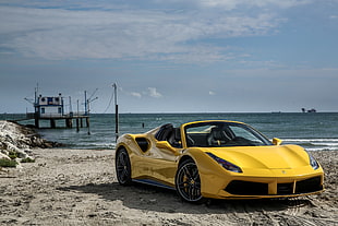 yellow Ferrari 458 Italia car on seashore near dock under white clouds
