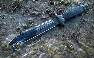 black combat knife on mud