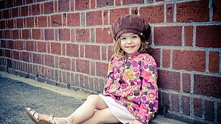 girl in pink and purple jacket with white skirt wearing maroon hat