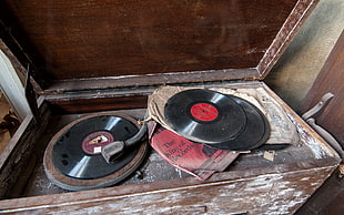 assorted vinyl records with brown wooden vinyl record player