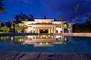 white concrete house near swimming pool during nighttime