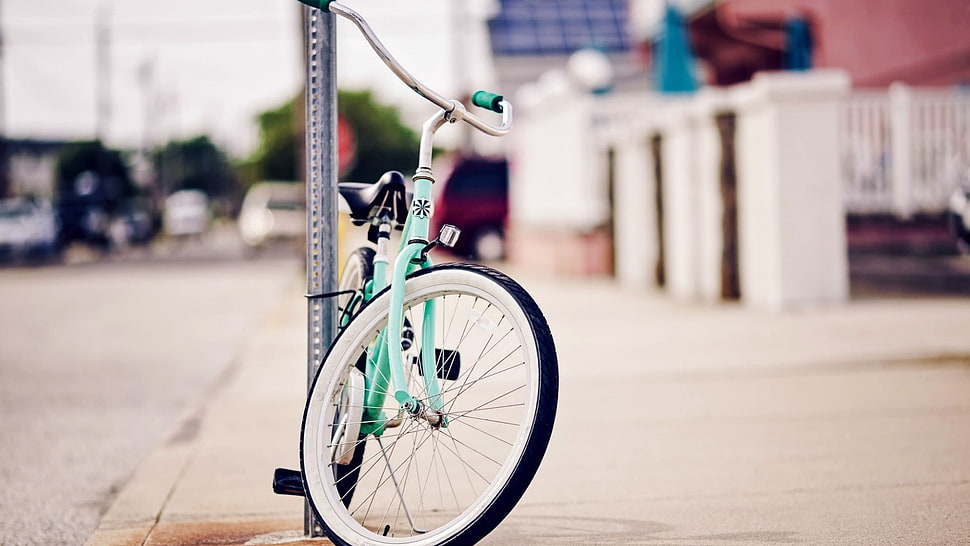 teal and white cruiser bike parked beside post HD wallpaper