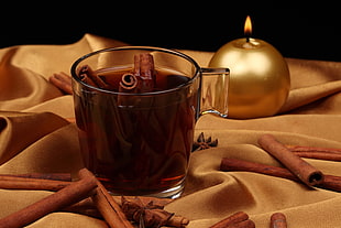 clear drinking glass with brown cinnamon sticks