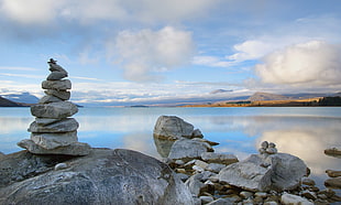 rock cairn beside body of water