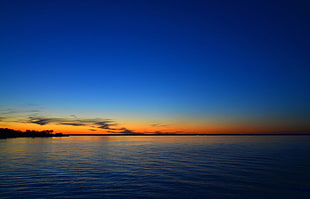 wide body of water horizon during sunset