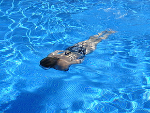 photo of woman swimming on pool